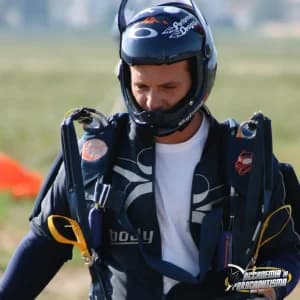 Paracadutista con casco e imbracatura completa a bordo pista, pronto a salire in aereo